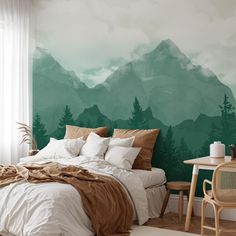 a bedroom with a mountain mural painted on the wall and bed in front of it