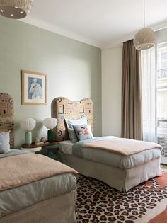 two beds in a bedroom with animal print rugs on the floor next to each other