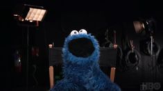 the sesame character is sitting in a chair