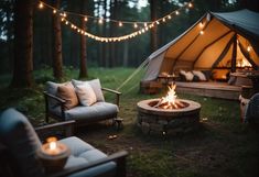 an outdoor fire pit surrounded by chairs and lights in the woods with a canvas tent behind it