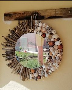 a mirror that is on the side of a wall with seashells in it