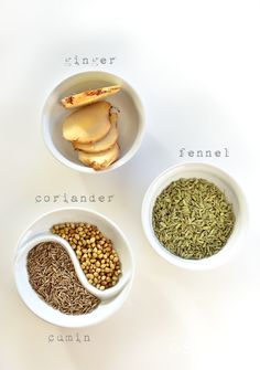 three bowls filled with different types of spices on top of a white countertop next to each other