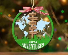 a christmas ornament hanging from a tree with a world map in the background