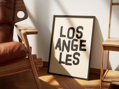 a poster that reads los angeles lies next to a chair