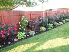 the garden is full of colorful flowers and plants in pots on the side of the fence