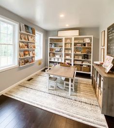 a living room filled with lots of furniture and bookshelves next to a window