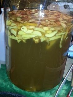 a large jar filled with liquid sitting on top of a green tablecloth covered counter