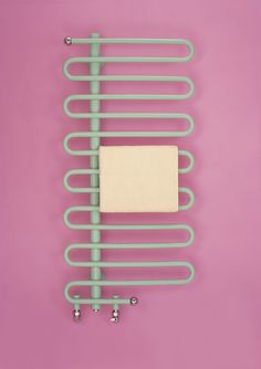 a towel is hanging on the side of a radiator in front of a pink wall