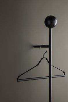 a black coat hanger on a white wall