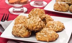 some cookies are on a white plate with silverware next to it and two glasses