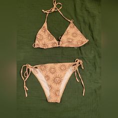 This Stunning New Without Tags 3-Piece Bikini Set Features A Beautiful Moon And Sun Pattern In Brown With A Dark Mustard Background Colors. The Set Includes A Bikini Top, Cover-Up, And Bikini Bottom, All Made Of A Comfortable Blend Of 82% Polyester And 18% Spandex Materials. The Bikini Is Machine Washable, Making It Easy To Care For. The Top And Bottom Have A Tie Straps Accent And Is Designed With Removable Pads For Added Comfort. The Bikini Cover-Up Is Sheer, Adding A Touch Of Bohemian Style To Boho Bikinis, Brown Beachy Swimwear For Beach Season, Brown Floral Print Beach Bottoms, Brown Cotton Beachwear Bottoms, Summer Brown Swimwear With Tie-side Bottom, Brown V-neck Swimwear For The Beach, Resort Look, Moon Print, Printed Ties