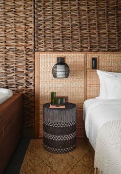 a bedroom with wicker walls and a bed in the corner next to a night stand