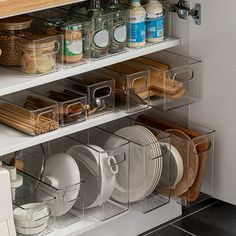 an organized kitchen cabinet with dishes and utensils