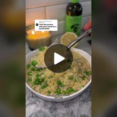 a bowl filled with rice and peas next to a candle