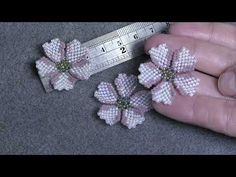 someone is measuring the size of their flower brooches with a ruler in front of them