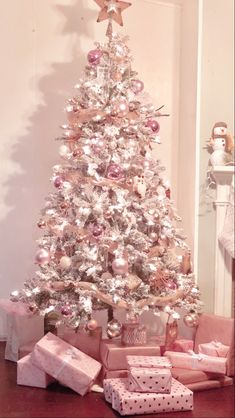 a white christmas tree with presents under it