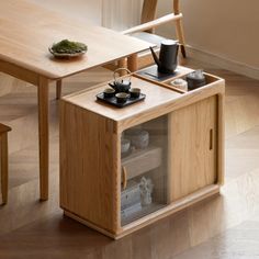 a small wooden table with two cups on it and a tea pot in the middle