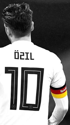 a man with his back turned to the camera wearing a germany soccer jersey and holding his hands behind his back