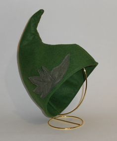 a green hat with an embroidered leaf on it