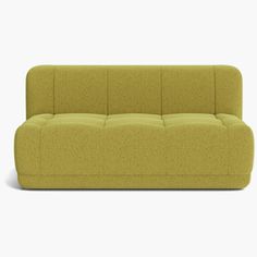 a green couch sitting on top of a white floor