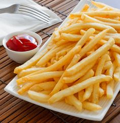 french fries on a plate with ketchup and sauces next to it,