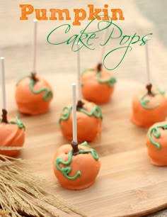 pumpkin cake pops with green icing on a wooden board