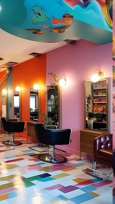 the interior of a hair salon with colorful walls and floor tiles on the ceiling, chairs in front of mirrors