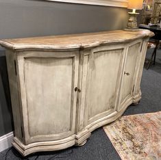 an old white cabinet is next to a rug