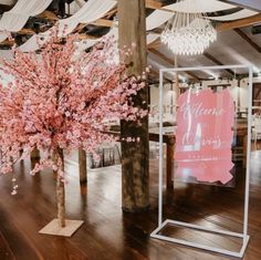 a tree with pink flowers is in the middle of a room