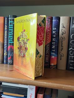 several books on a book shelf in a library, one is yellow and the other is red