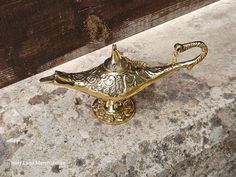 a golden metal object sitting on top of a stone counter next to a wooden wall