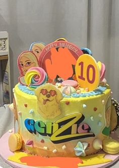 a birthday cake with the number ten on it, decorated in yellow and pink icing