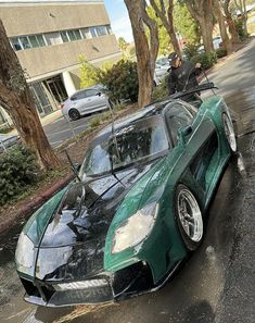 a green sports car is parked on the street