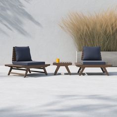 two chairs and a coffee table in front of a white wall