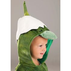 a young boy wearing a green dinosaur costume with a white hoodie on his head