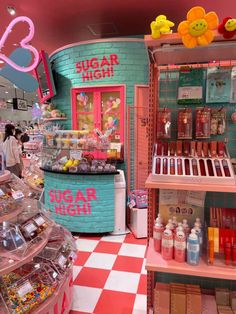 the inside of a candy shop with pink and blue walls, checkered flooring and shelves