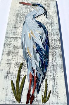 a bird made out of stained glass sitting on top of a piece of art paper