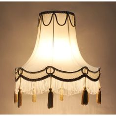 a lamp shade with tassels hanging from it