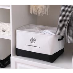 a white and black storage box sitting on top of a shelf