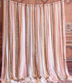 a pink and gold striped curtain hanging on a wall