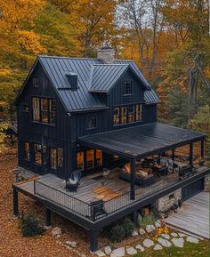 this is an aerial view of a house in the woods with fall foliage surrounding it