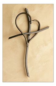 a pair of scissors shaped like a heart on a stone wall with a cross in the middle