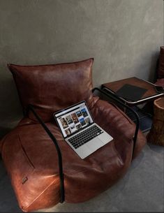 a laptop computer sitting on top of a leather chair