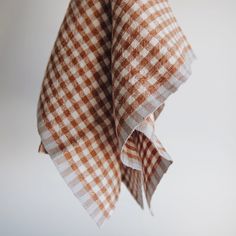 a brown and white checkered cloth hanging from a hook on a wall or ceiling