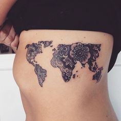 a woman with a tattoo on her stomach showing the world map in black and white