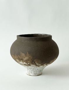 a brown and white vase sitting on top of a table