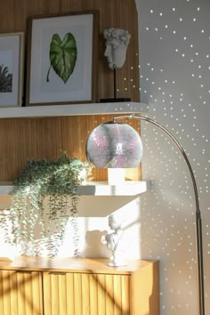 a living room with a lamp and some pictures on the wall above it that is decorated with white polka dots