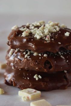 three pieces of chocolate covered cookies sitting on top of each other with white and brown sprinkles