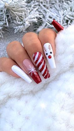 a woman's hand with red and white christmas themed nails