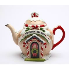 a teapot shaped like a house with candy canes on the outside and peppermint tea shop on top